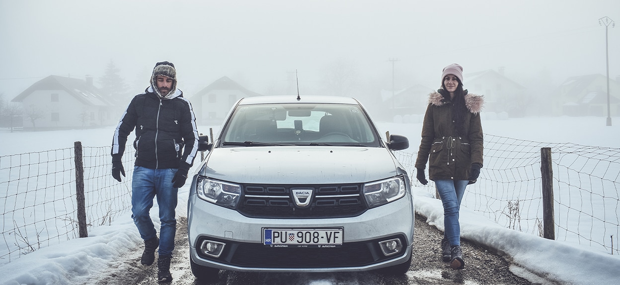 A couple near a car in the snow