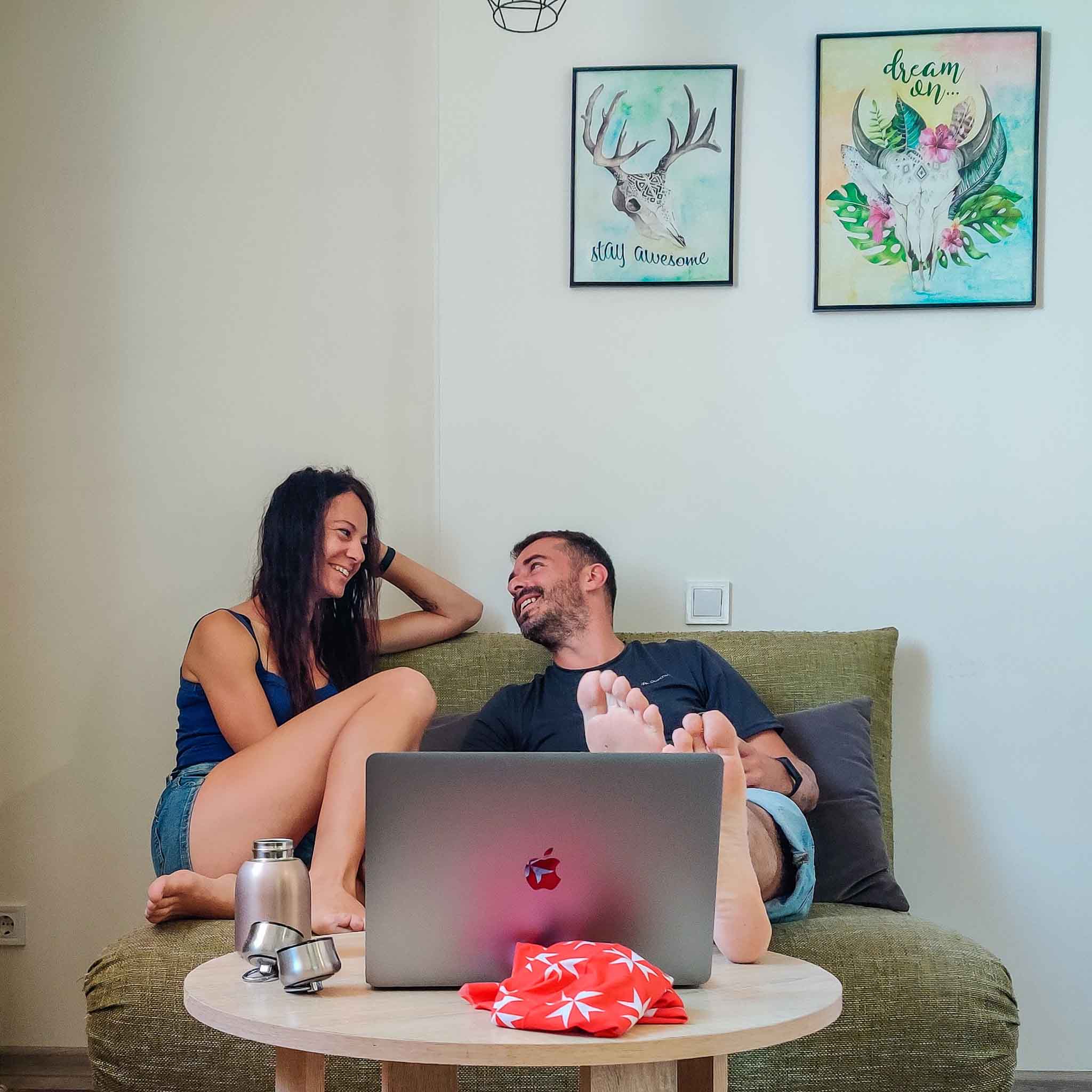 A couple with a Macbook laughing