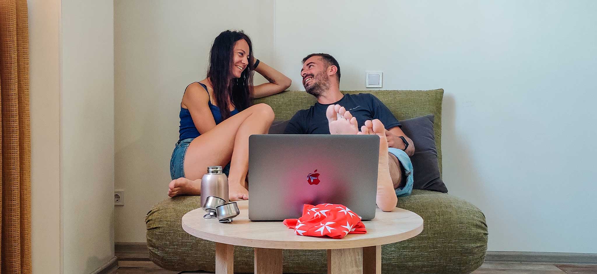 A couple with a Macbook laughing