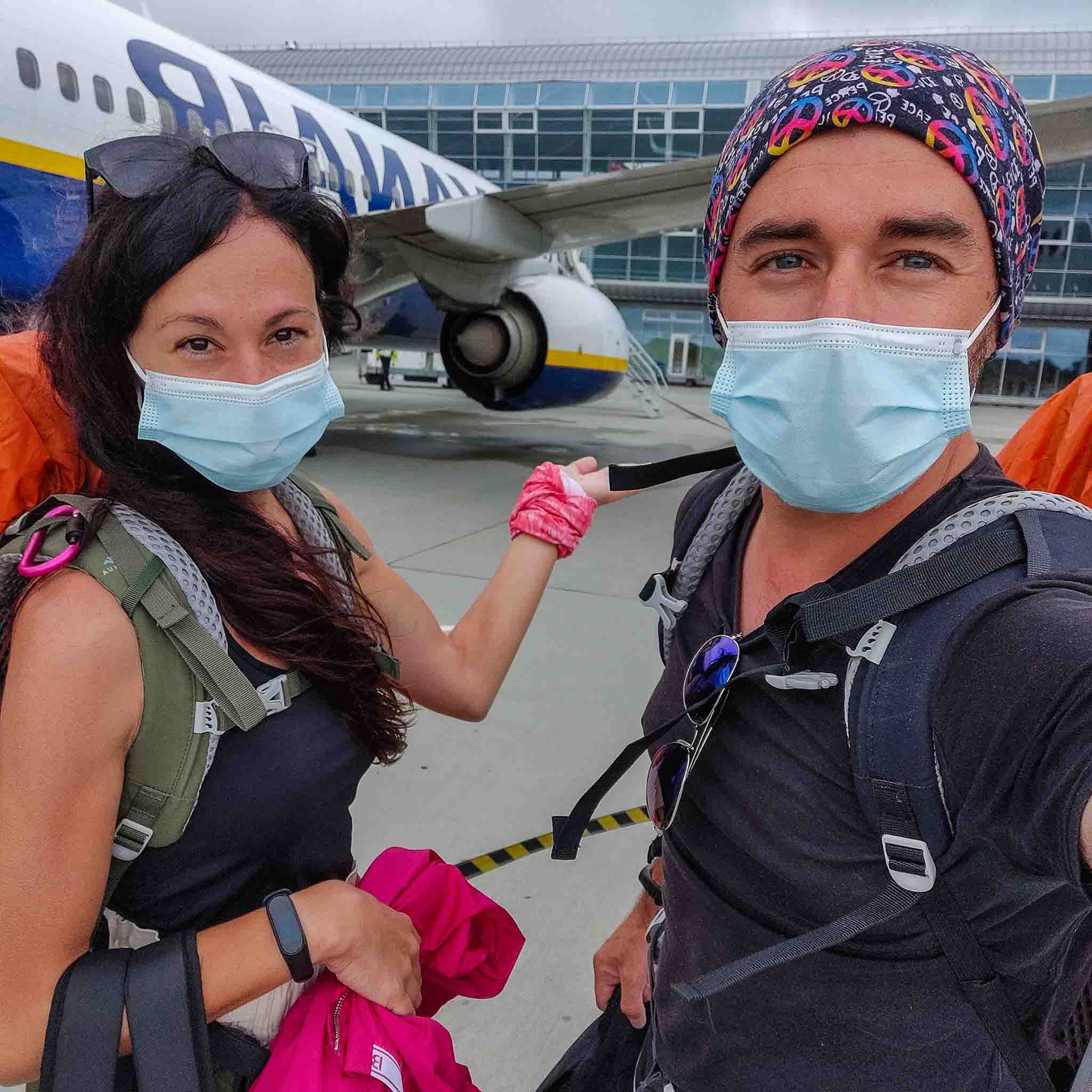 A couple wearing masks near a plane in Lviv Airport