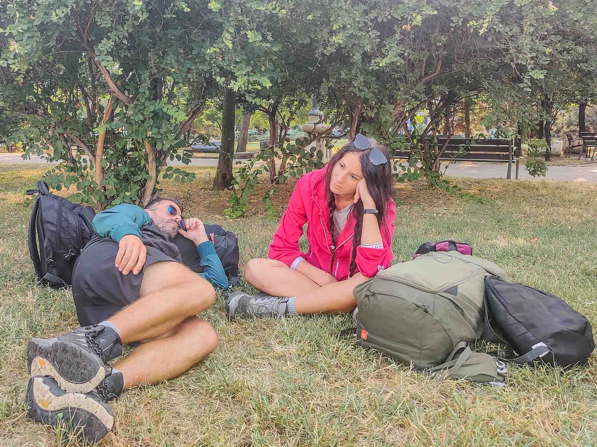 A couple resting on the grass in a park