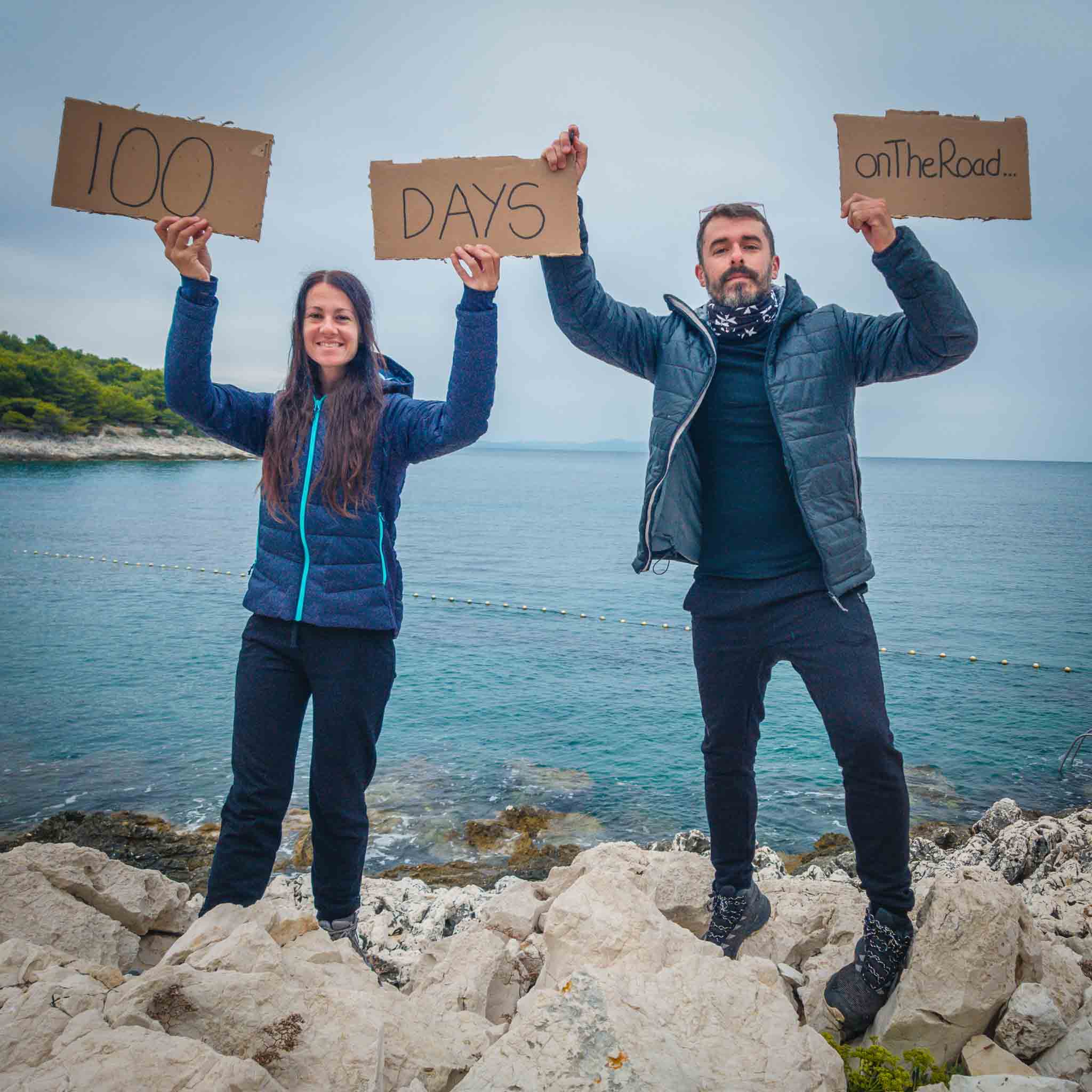 A couple holding a sign 100 days on the road